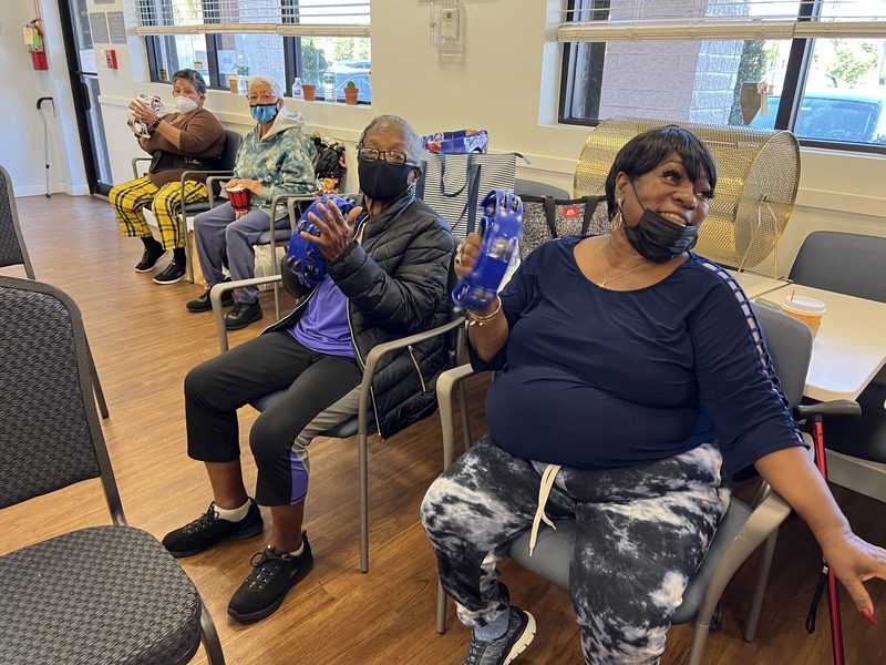 Members using hand weights during a seated class